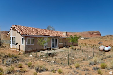Rear view of house with a tile roof, stucco siding, and a patio area