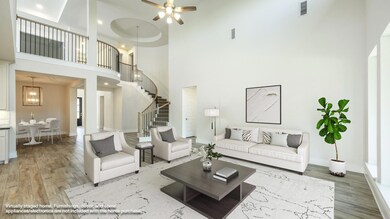 Living area with a towering ceiling, light wood-t