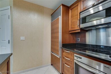 Kitchen with dark countertops, brown cabinetry, an