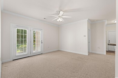 living room with ceiling fan, light carpet, and cr