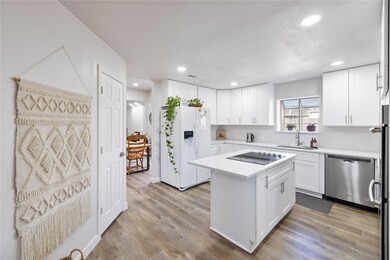 Kitchen featuring black electric cooktop, white ca