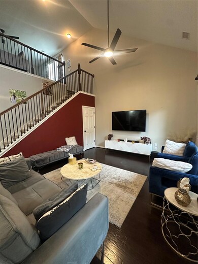 Living room featuring a ceiling fan, wood-type fl