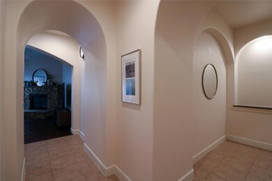 Hallway with light tile patterned floors and baseb
