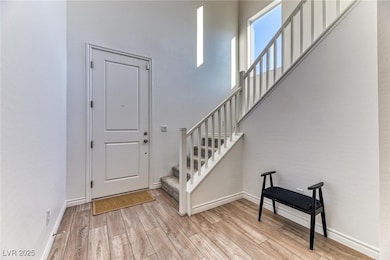Foyer entrance with light wood-style floors and stairs