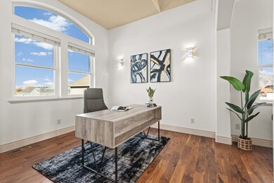 Home office with dark wood-style flooring and plenty of natural light