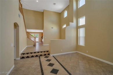 Foyer entrance with arched walkways, stairway, til