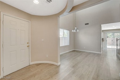 Foyer with a chandelier, light wood-type flooring,