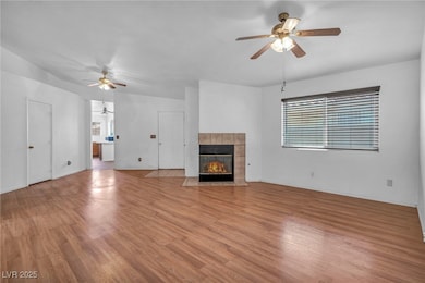 Unfurnished living room featuring a ceiling fan, l