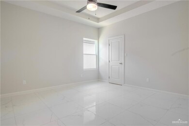 Spare room with a tray ceiling and ceiling fan