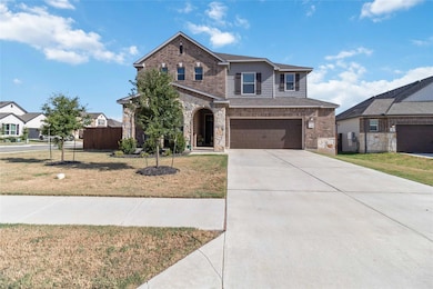 View of front facade featuring brick siding, concrete driveway, an attached garage, and stone siding