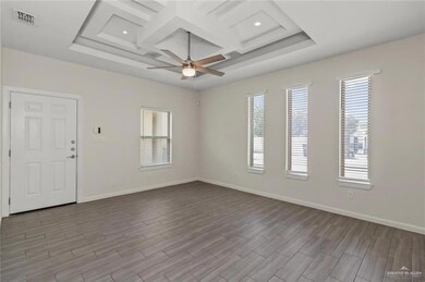 Spare room featuring light wood-type flooring, ceiling fan, and plenty of natural light