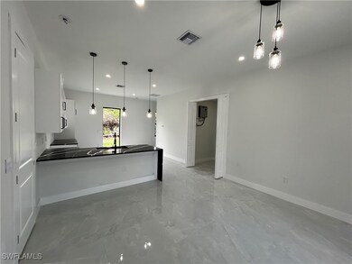Kitchen featuring white cabinets, dark countertops