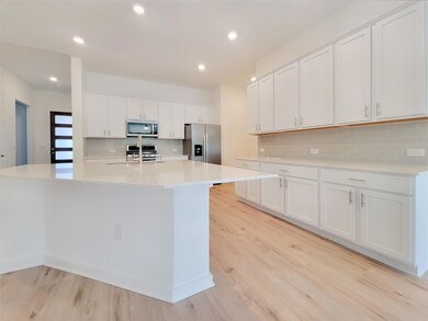 Kitchen with light wood-type flooring, white cabi