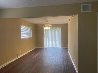 Unfurnished room featuring a textured ceiling, dark wood-style flooring, and ceiling fan
