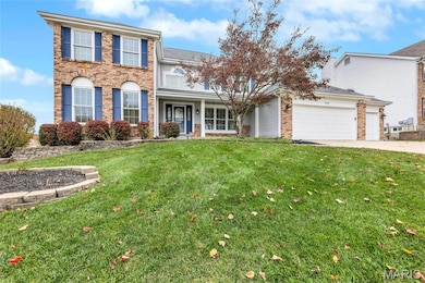 View of front of home featuring a front yard, brick siding, driveway, covered porch and a 3 car attached garage
