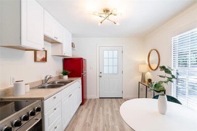Kitchen featuring white cabinetry, light countert