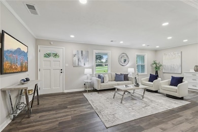 Living room with ornamental molding, dark wood-style floors, recessed lighting, and baseboards