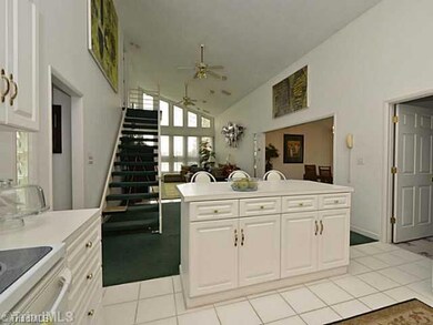 Interior Space/Layout. Looking from the kitchen, notice the bright and open space. The far wall of windows look out over the lake and the stairs lead up to your private master suite.  The formal dining room can be seen toward the right. Door on right is to large Laundry room.