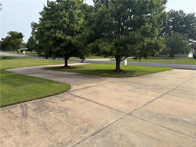 featuring a lawn and curved driveway