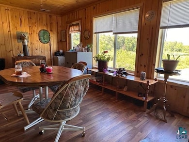 Dining area with wood walls, wood finished floors, and wood ceiling