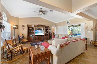 Tiled living room featuring ceiling fan, crown mol