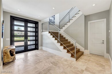 Entrance foyer featuring french doors, stairway, m