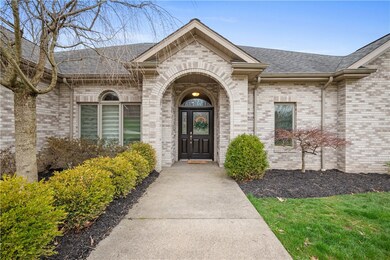 Covered entry with mature landscaping.