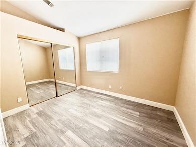 Unfurnished bedroom with wood finished floors, lof