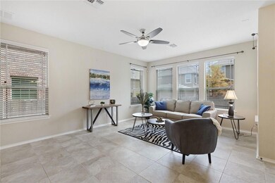 Living area with a ceiling fan and light tile patterned flooring