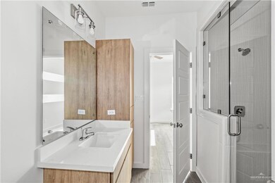 Bathroom featuring hardwood / wood-style flooring, vanity, and an enclosed shower