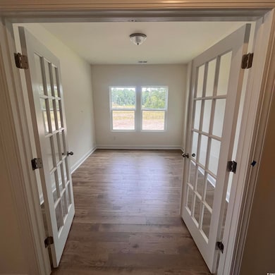 study featuring french doors and wood finished floors. first level.