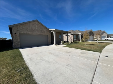 Ranch-style house featuring a front lawn, concrete driveway, an attached garage, and brick siding