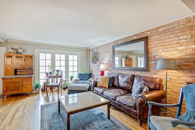 A huge wireless TV can be put on the brick wall and furniture rearranged