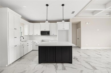 Kitchen featuring white cabinetry, pendant lighting, light tile floors, and sink