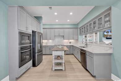 Kitchen featuring gray cabinetry, light stone coun
