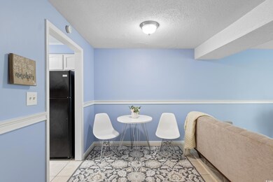 Tiled dining area with a textured ceiling and baseboards