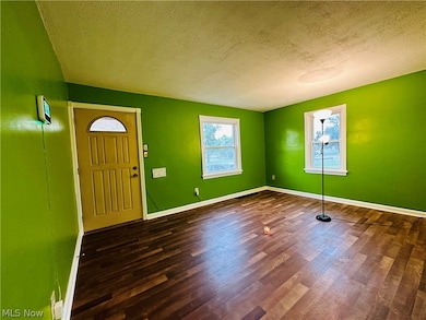 Wood floored foyer with a textured ceiling