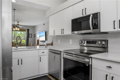 Kitchen featuring appliances with stainless steel finishes, backsplash, white cabinets, and ceiling fan