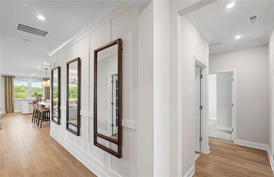 Model RepresentationHallway with light wood-style floors, recessed lighting, and baseboards