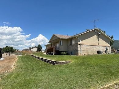 View of property exterior featuring brick siding, a deck, and stucco siding
