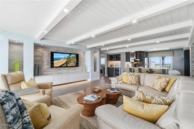 Living area with beam ceiling, wood finished floors, recessed lighting, and wine cooler
