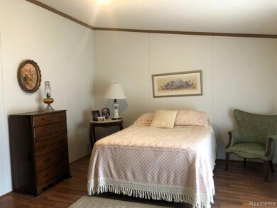 Bedroom with ornamental molding, dark wood-style flooring, and a textured ceiling