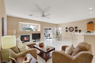 Living area with visible vents, a ceiling fan, a g