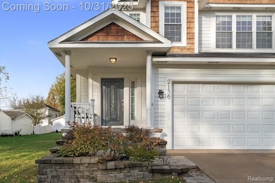 Doorway to property with a porch, a garage, driveway, and a lawn