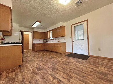 Kitchen with hardwood / wood-style floors and a te