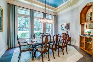Elegant formal dining room with treyed ceiling, lots of crown molding and tons of natural light.