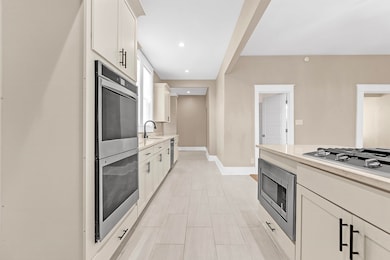 Kitchen featuring stainless steel appliances, light countertops, white cabinetry, and recessed lighting