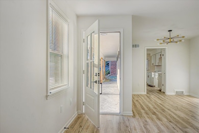 Doorway to outside with healthy amount of natural light and wood finished floors