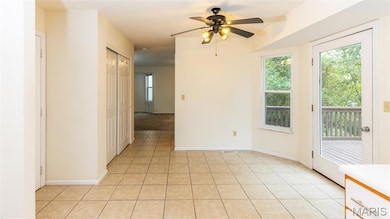 Empty room featuring light tile patterned floors and a ceiling fan