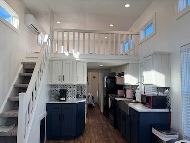 Kitchen with white cabinets, decorative backsplash, blue cabinets, healthy amount of natural light, and recessed lighting